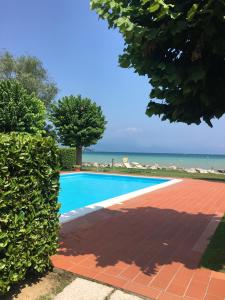 a swimming pool with the ocean in the background at Lugana 17 in Sirmione