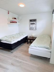 a room with two beds and a table in it at Det lille hus in Viborg
