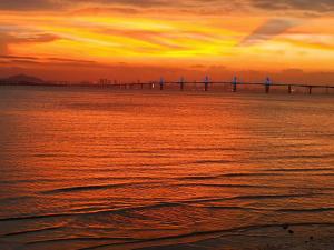 a bridge over a body of water at sunset at Ferry Bow in Jincheng