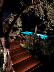 a wooden stairs leading to a swimming pool at night at Villa Torre Conca Cefalu Coast in Finale +61 photos