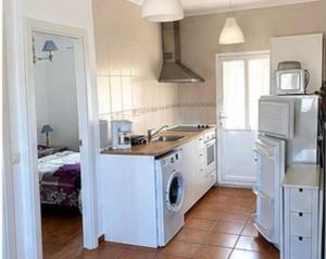 a kitchen with a sink and a washer and dryer at Apartamentos Las Fuentes in Labajos