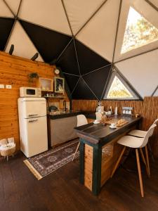 a kitchen with a refrigerator and a table in a room at AL-hakoura in Mas'ada