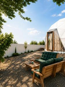 a garden with a green couch and a greenhouse at AL-hakoura in Mas'ada