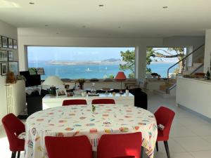 a dining room with a table and chairs with a view of the ocean at Paradis sur l'Aber in Landéda