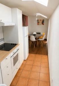 a kitchen with white cabinets and a table with chairs at Apartamentos Las Fuentes in Labajos +16 photos