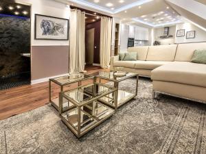 a living room with a couch and a glass coffee table at Boutique Suites and Residences Heidelberg- Alte Zigarrenmanufaktur in Heidelberg