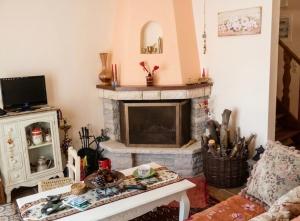 a living room with a fireplace and a table at Dreamcatcher Maisonette No.2 in Kalavrita