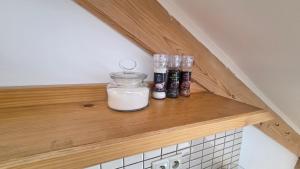 a shelf with a jar of yogurt and spices at PARADAJS City Center Apartments - 24h self check-in & free private parking in Spišská Nová Ves
