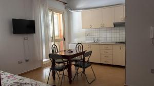 a kitchen with a table and chairs in a room at A&A Aparthotel in Orikum