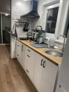 a kitchen with white cabinets and a sink at Дача у моря-2 in Vapnyarka