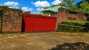 a red gate in a brick building with a brick wall at Naisi spur in Zomba