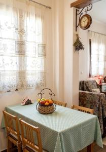 a dining room table with a basket of fruit on it at Dreamcatcher Maisonette No.2 in Kalavrita