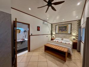 a bedroom with a bed and a ceiling fan at Beach Villa Guesthouse in Grand Anse