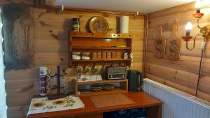 a room with a wooden wall with a table and a clock at Chata Milka in Medzilaborce
