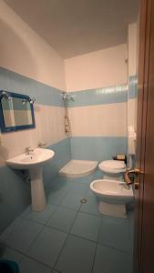 a bathroom with two toilets and a sink at A&A Aparthotel in Orikum