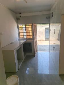 an empty room with a counter and a window at Chimwemwe apartments in Chingola