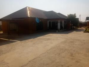 a large brown building with a dirt lot in front of it at Chimwemwe apartments in Chingola