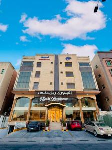 a building with cars parked in front of it at Al Jury Serviced Apartments in Al Khobar