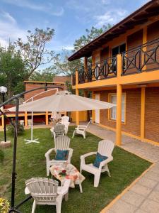 a group of chairs and an umbrella in a yard at Complejo sierras de brochero in Villa Cura Brochero