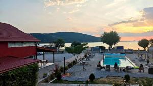 ein Resort mit Schwimmbad und einem Gewässer in der Unterkunft Casa Legrand in Baziaş