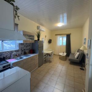 a kitchen and living room with a couch and a table at Saint Giovanni House in Kharokopión