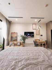 a bedroom with a bed and a desk and a television at The Opus One 1 in Long Bình +12 photos