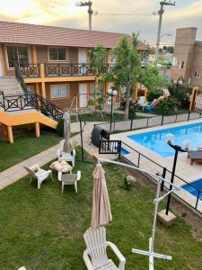 a backyard with a pool with chairs and a table at Complejo sierras de brochero in Villa Cura Brochero