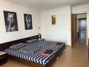 a bedroom with a bed with a black and white comforter at Sozopol Sunrise A in Sozopol