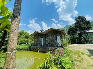 a small house in the middle of a body of water at Du Già Khánh Chung homestay in Yên Minh