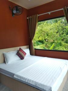 a bed in a room with a window at Du Già Khánh Chung homestay in Yên Minh