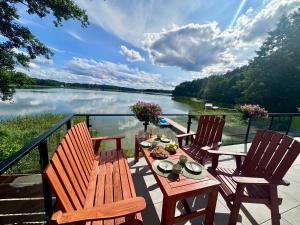 a table and chairs on a deck with a view of a lake at Szept Wody Kaszuby in Lubiana
