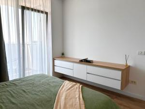 a bedroom with a bed and a dresser with a window at V'One - Cozy & Quiet Apartment - Free Parking in Timişoara