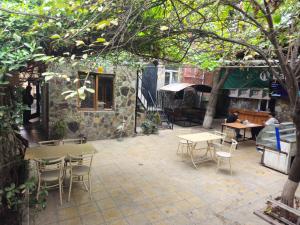 a patio with tables and chairs and a building at Oscar Hotel Guba in Quba