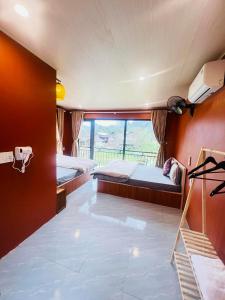 a bedroom with two beds and a large window at Du Già Khánh Chung homestay in Yên Minh +14 photos