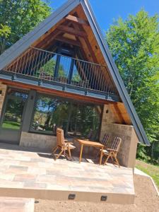 ein Haus mit Terrasse, Tisch und Stühlen in der Unterkunft Chalet SOFI in Šavnik