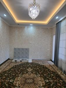 a large room with a fireplace and a chandelier at Guest House FAIZ homestay in Panjakent