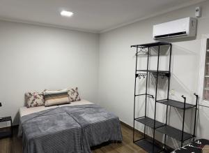 a bedroom with a bed and a book shelf at Maia Hostel in Várzea Grande