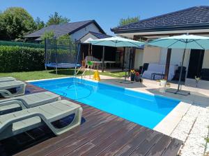 a swimming pool with two umbrellas in a yard at MARINA HOUSE pool & garden in Beograd