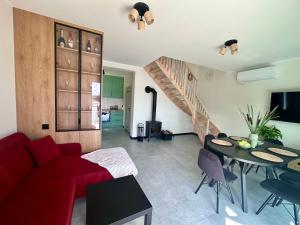 a living room with a red couch and a table at Szept Wody Kaszuby in Lubiana +33 photos