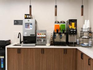 a kitchen counter with a coffee maker on it at Hotel Royale - Houston Hobby Airport in Houston