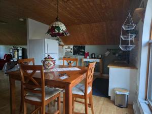 a kitchen with a wooden dining table and chairs at La Maison Pamaljolie in Ayers Cliff