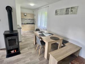 a room with a table and a wood stove at Chaloupka Všemily in Jetřichovice