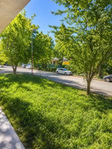 a green lawn with trees on the side of a street at AnaBella Apartments Gabrovo in Gabrovo