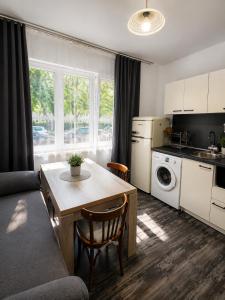 a living room with a table and a kitchen at AnaBella Apartments Gabrovo in Gabrovo