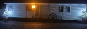 a small house with a light on the door at night at The barn in Carmarthen