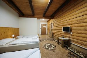 a bedroom with a wooden wall with a bed and a tv at Moto pub Marusja in Snina