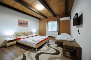 a bedroom with two beds and a flat screen tv at Moto pub Marusja in Snina