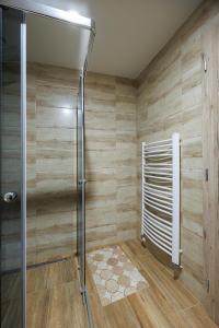a shower stall in a bathroom with wooden walls at Moto pub Marusja in Snina +37 photos