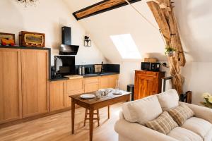 a living room with a couch and a table at Le Grenier - Air conditioning - Free parking in Nogent-sur-Vernisson