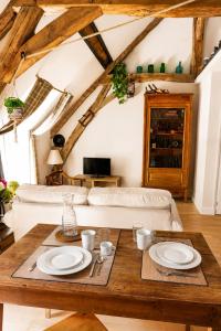 a living room with a table and a couch at Le Grenier - Air conditioning - Free parking in Nogent-sur-Vernisson